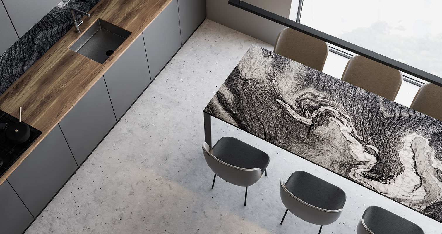 Cucina moderna con mobili grigi, piano in legno, tavolo marmorizzato e sedie beige vicino a una grande finestra.