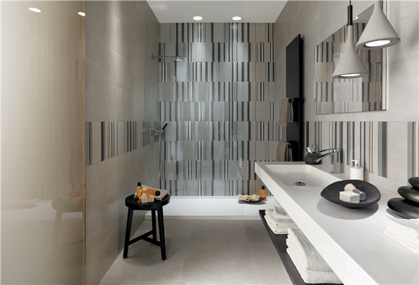 Bagno moderno grigio con doccia walk-in a fasce verticali, grande specchio, piano bianco e arredi eleganti.