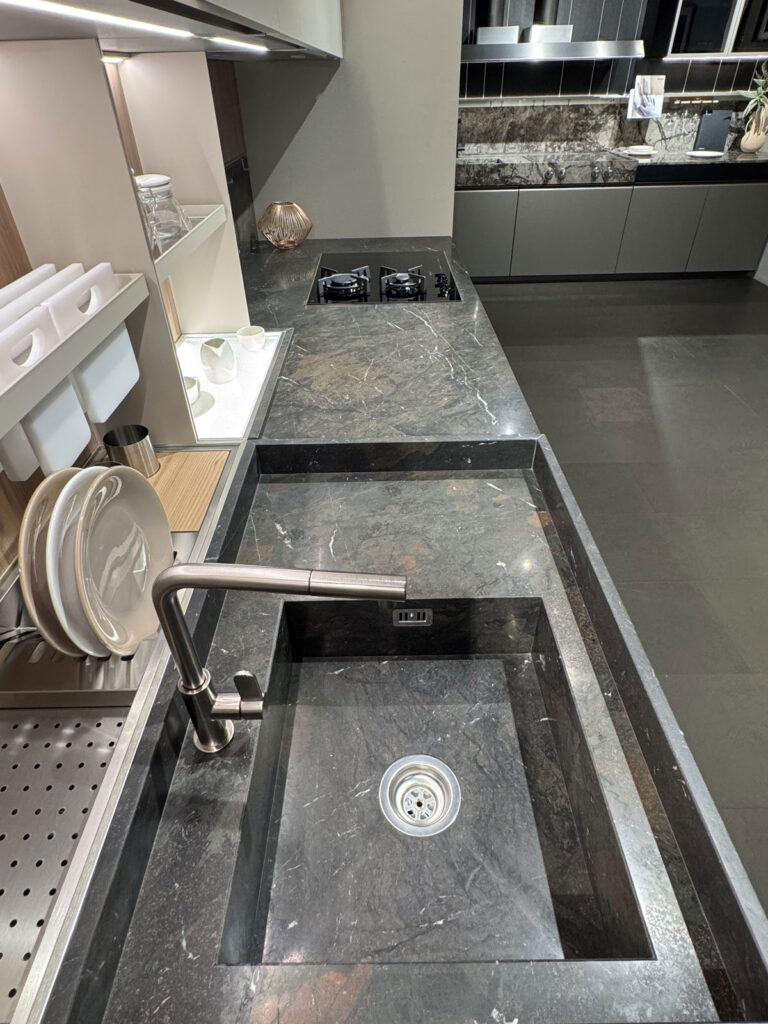 Piano cottura e lavello integrati nel top in pietra scura di una cucina Ernestomeda K-Lab