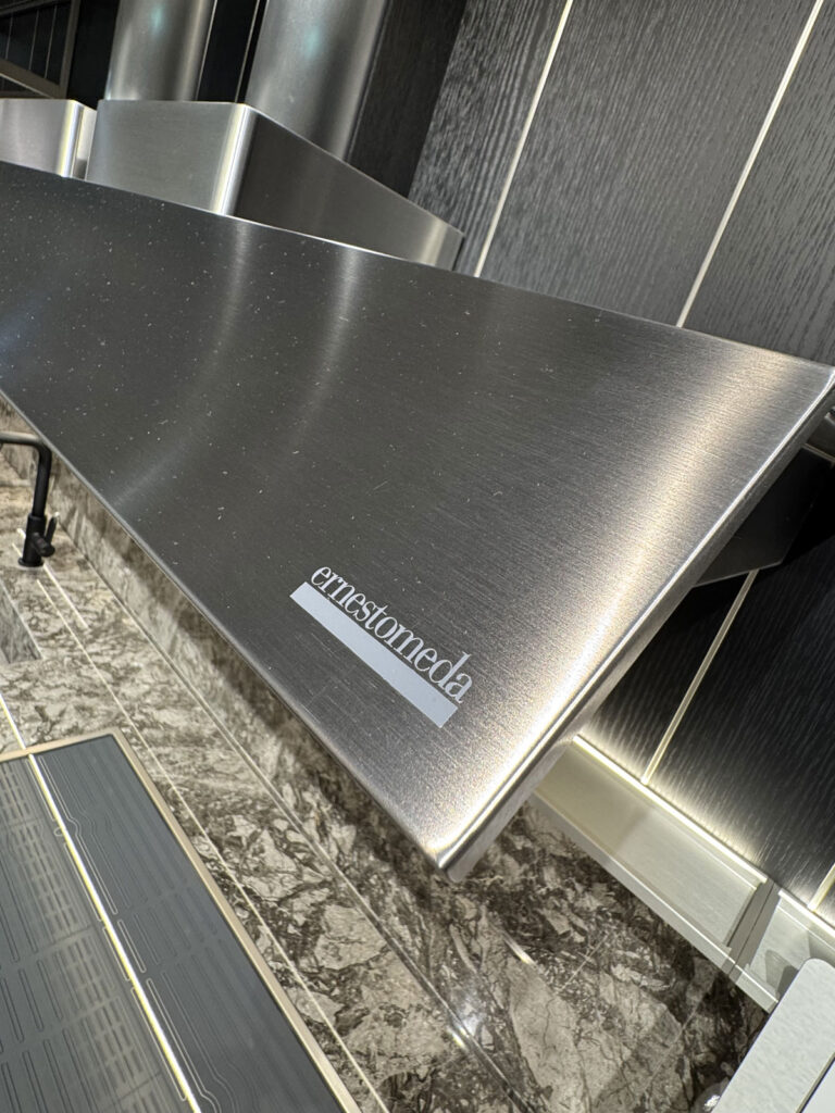 Cappa da cucina in acciaio inossidabile Ernestomeda K-Lab su piastrelle scure e piano in marmo, design moderno per la zona cucina.