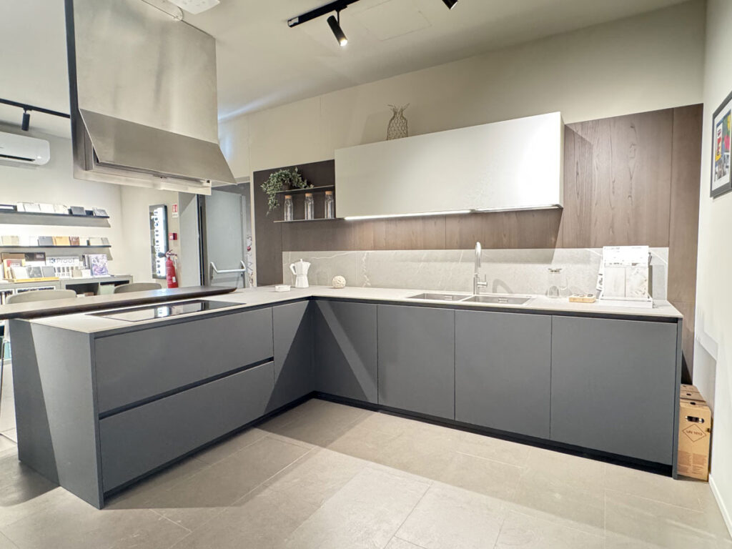 Cucina Ernestomeda One 80 ad angolo con ante grigie, pensili chiari e piano cottura a induzione
