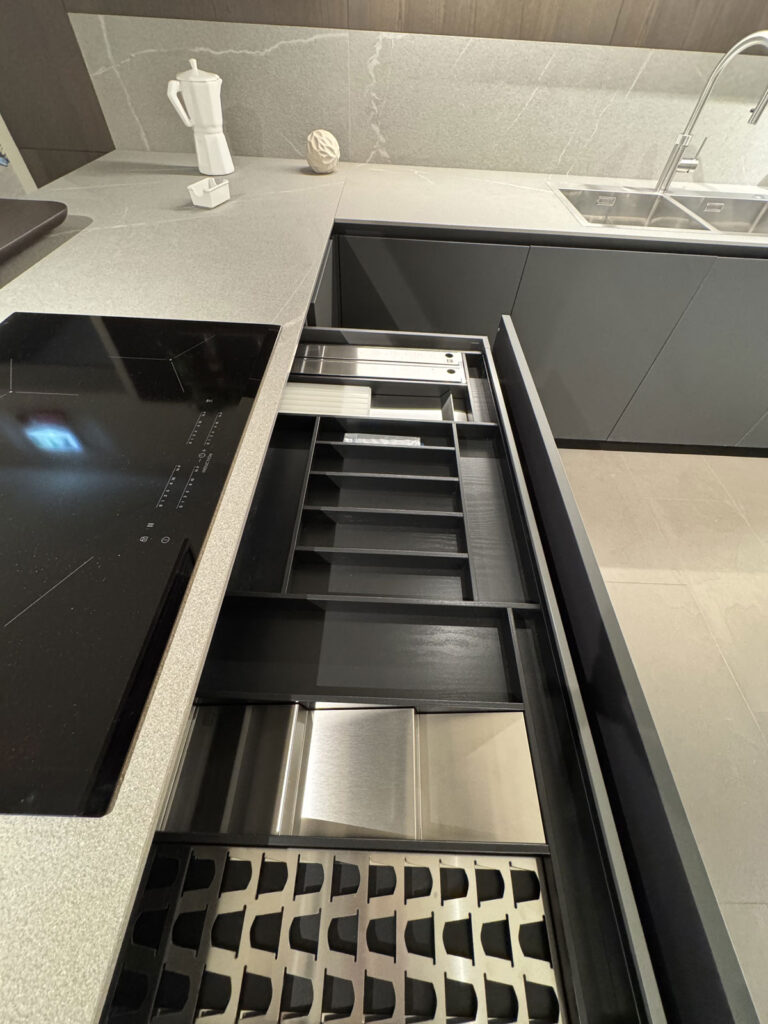 Cassetti attrezzati aperti sotto il piano cottura a induzione di una cucina Ernestomeda One 80