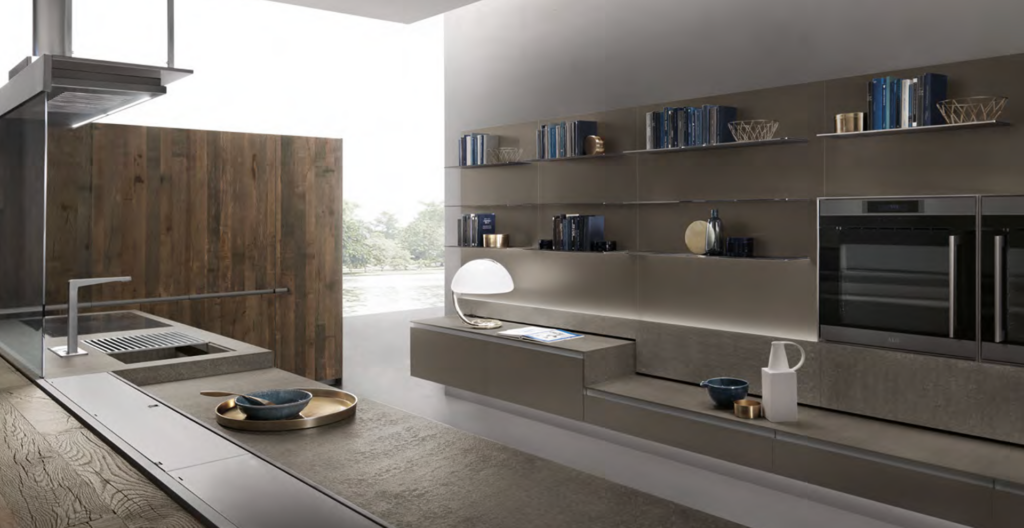 Cucina moderna con mensole a vista, forno da incasso, piano di lavoro lungo con lavello e ampia finestra luminosa.