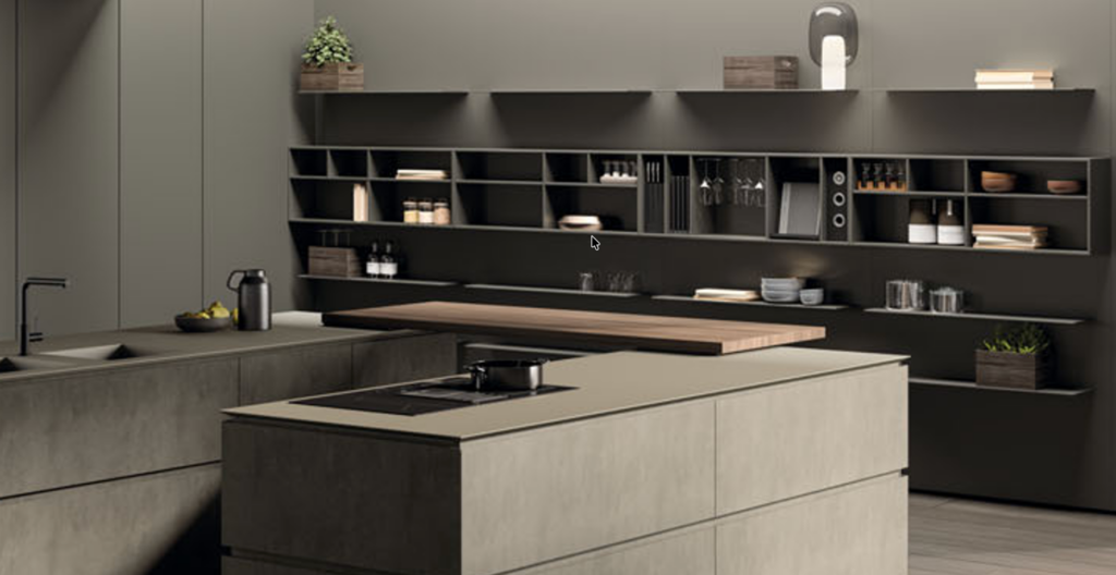 Cucina moderna con mobili grigi in stile minimalista, isola con piano cottura e mensole a vista, illuminazione soffusa.