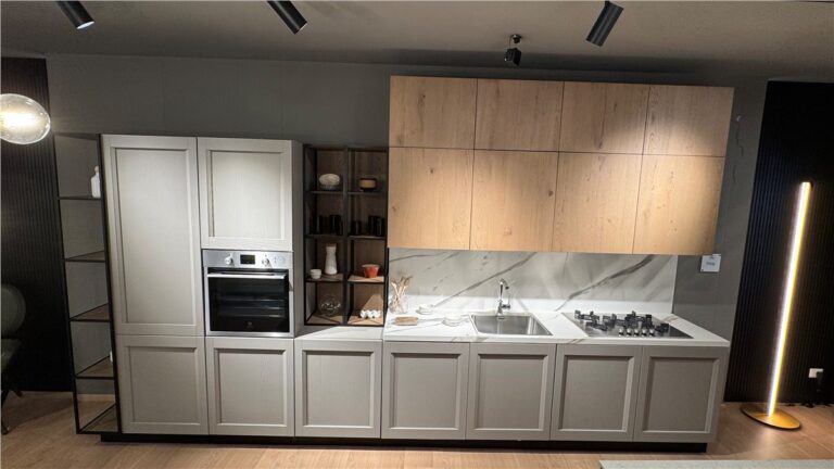 Cucina moderna Arredo 3 con mobili grigio chiaro, pensili in legno, forno da incasso e piano di lavoro in marmo bianco.