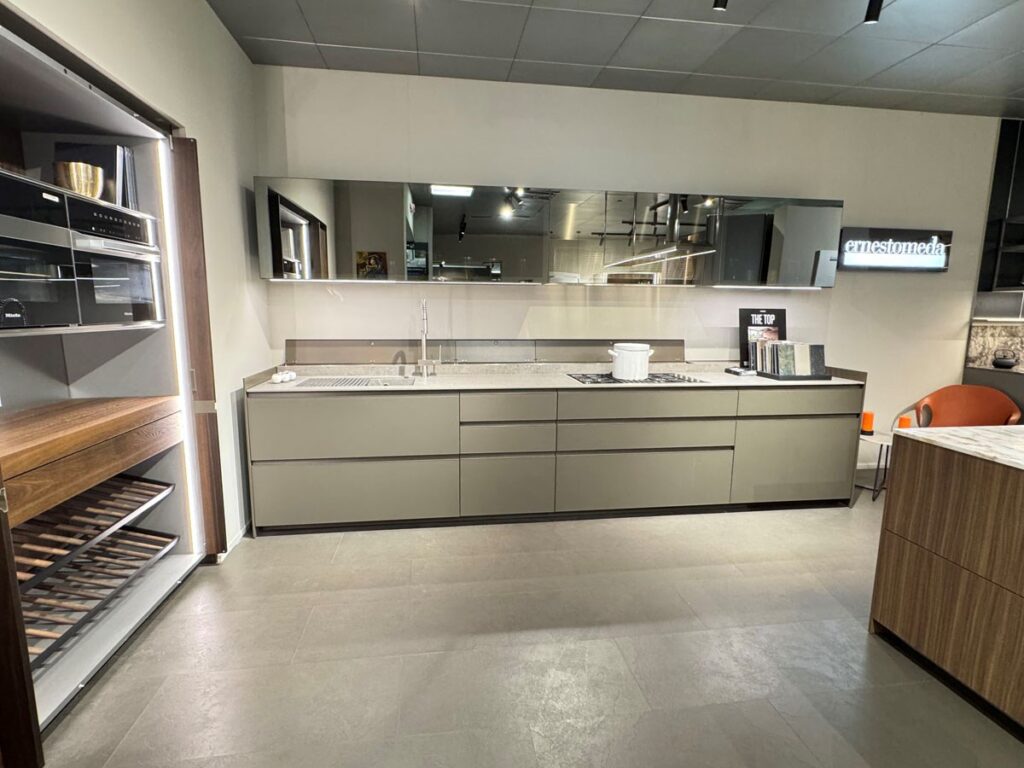Cucina moderna Arredo 3 Icon con mobili grigi, piano di lavoro con lavello e piano cottura, forno da incasso e paraschizzi a specchio.