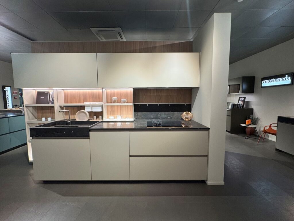 Vista d'insieme di una cucina Ernestomeda Soul chiara con top scuro in showroom