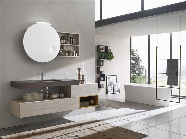 Bagno ospiti con lavabo su mensola, specchio tondo e vasca sullo sfondo