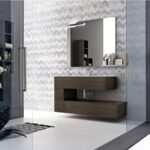 Bagno con mobile sospeso scuro, parete a rilievo e specchio illuminato