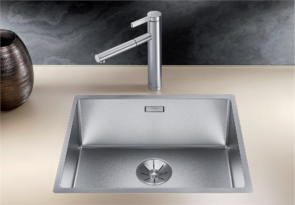 Lavello in acciaio sottotop con miscelatore alto e vaso decorativo su fondo scuro