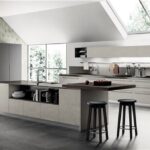 Cucina in mansarda con isola scura, sgabelli e lucernari