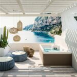 Minipiscina idromassaggio in una veranda con parete decorata a paesaggio marino