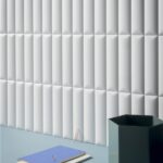 Parete rivestita con piastrelle bianche tridimensionali a listelli verticali