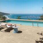 Bordo piscina in gres effetto pietra con lettini affacciati sul mare