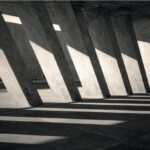 Interno architettonico in cemento con fasci di luce dalle aperture verticali
