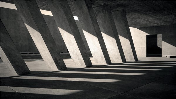 Interno architettonico in cemento con fasci di luce dalle aperture verticali