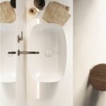 Lavabo integrato in un piano bianco visto dall'alto con accessori in legno