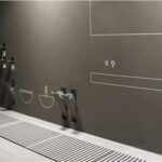 Accessori bagno a parete in metallo scuro con asciugamano e doccia a pavimento