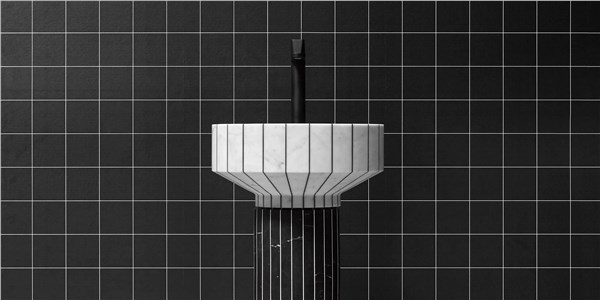Lavabo a colonna scanalato su parete rivestita in mosaico nero