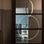 Lampada a sospensione con anelli luminosi circolari in un ambiente scuro