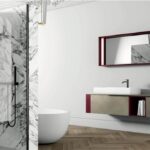 Bagno con parete effetto marmo, doccia e mobile sospeso con specchio