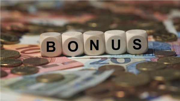 Cubi con la scritta bonus appoggiati su banconote e monete