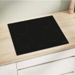 Piano cottura a induzione nero incassato in un top in legno chiaro