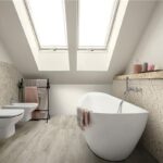 Bagno in mansarda con parete in pietra, vasca freestanding e sanitari sospesi