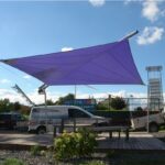 Vela ombreggiante viola tesa su una struttura in un'area esterna