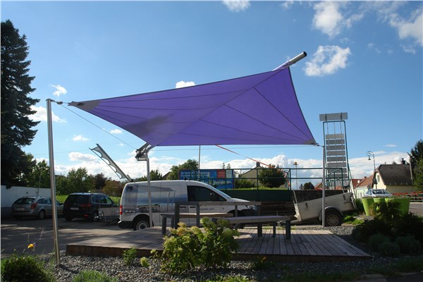 Vela ombreggiante viola tesa su una struttura in un'area esterna
