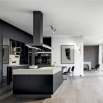 Cucina scura con isola, cappa aspirante a soffitto e pavimento in legno