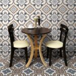 Tavolino e sedie su pavimento e parete in cementine decorate a motivi geometrici