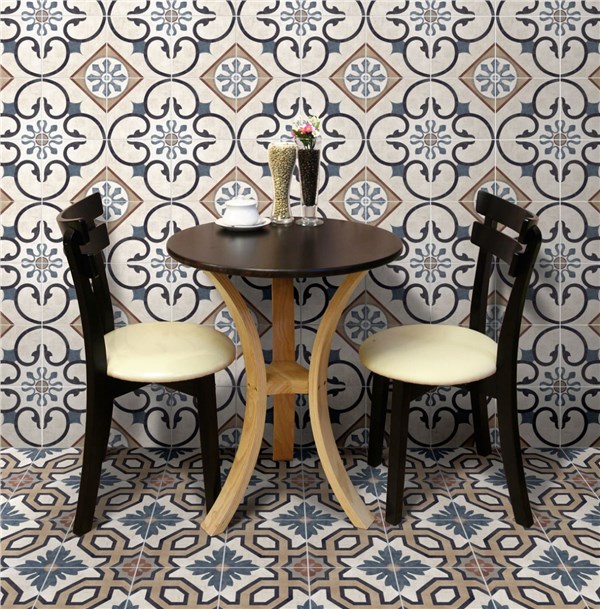 Tavolino e sedie su pavimento e parete in cementine decorate a motivi geometrici