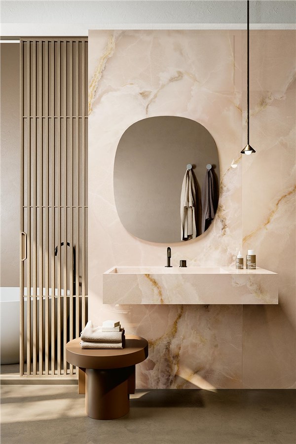 Bagno con parete in lastre effetto onice, lavabo sospeso e specchio ovale