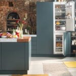 Cucina in stile industriale con frigorifero a due ante, mattoni a vista e isola