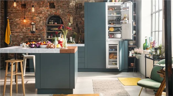 Cucina in stile industriale con frigorifero a due ante, mattoni a vista e isola