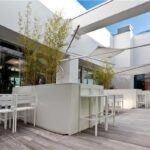 Terrazza con pergola a lamelle, tavolo da pranzo e vista sul giardino