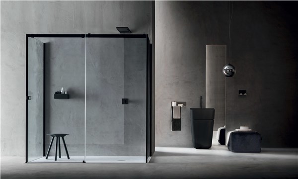 Box doccia con anta scorrevole e profili neri in un bagno effetto cemento