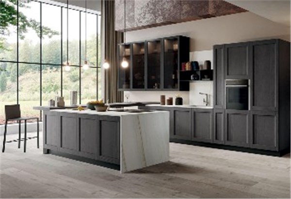 Cucina con isola, colonne scure e ampia vetrata affacciata sul verde