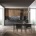 Cucina con isola scura, tavolo integrato e boiserie in legno