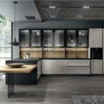 Cucina con isola, piano cottura a induzione e pensili a vetro