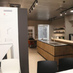 Esposizione di cucine Ernestomeda in un negozio con pannelli informativi