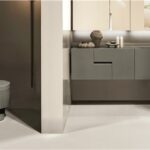 Bagno con mobile sospeso scuro, lavabo integrato e sanitari coordinati