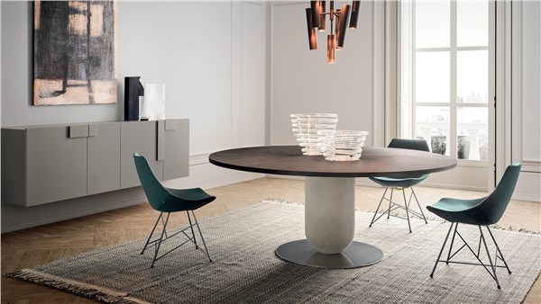 Tavolo ellittico con base centrale e sedie verdi in una sala da pranzo