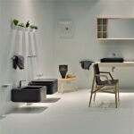 Sanitari sospesi neri e lavabo su mensola in un bagno bianco