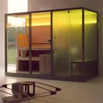 Cabina in vetro e legno con seduta e illuminazione interna calda