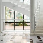 Ingresso con pavimento in marmo a intarsio geometrico e scala con ringhiera