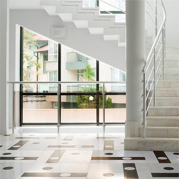 Ingresso con pavimento in marmo a intarsio geometrico e scala con ringhiera