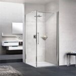Box doccia angolare in cristallo con profili cromati accanto a un mobile bagno