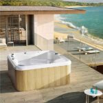 Minipiscina idromassaggio con rivestimento in legno affacciata sul mare